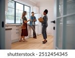 Happy couple talking with real estate agent while buying new home.