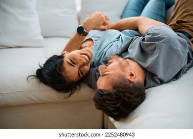 Happy couple talking while lying embraced on the sofa at home. - Shutterstock ID 2252480943