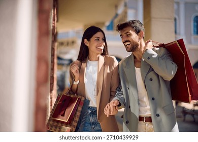 Happy couple talking while window shopping in the city. Copy space.