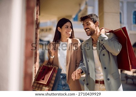 Happy couple talking while window shopping in the city. Copy space.
