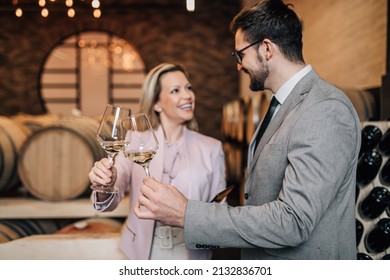 Happy Couple Tasting White Wine In Old Fashioned Winery. 