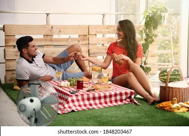 Happy Couple With Tasty Food Imitating Picnic At Home