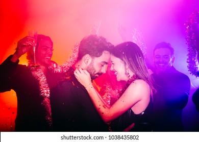 Happy Couple And Their Friends Dancing In Disco Club