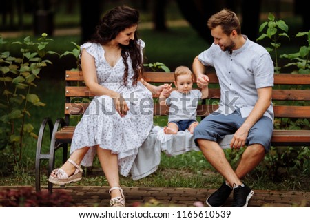 Happy couple with their little son in the park