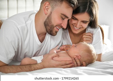 Happy Couple With Their Newborn Baby At Home