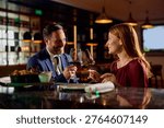 Happy couple toasting while drinking wine on a date night in restaurant. 
