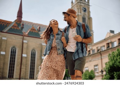 Happy couple of tourists laughing and having fun while walking in the city. Copy space. - Powered by Shutterstock