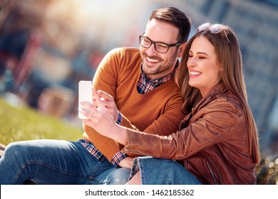 Happy couple of tourists taking selfie outdoors.