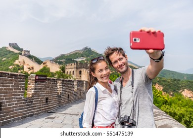 Happy Couple Tourists Taking Selfie Picture At Great Wall Of China, Top Worldwide Tourist Destination. Young Multiracial People Using Phone Photography App For Photos.