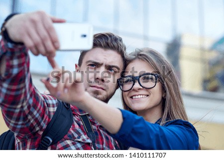 Similar – couple taking selfie in the street