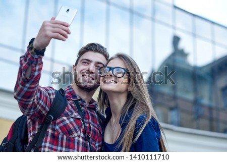 Similar – couple taking selfie in the street