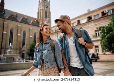 Happy couple of tourists talking while walking in the city.  - Powered by Shutterstock