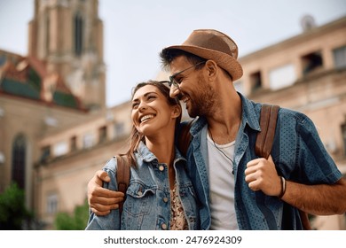 Happy couple of tourists walking embraced while sightseeing the town. - Powered by Shutterstock