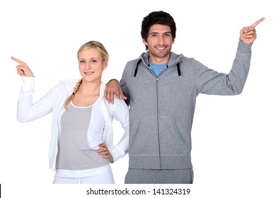 Happy Couple Training Together Pointing At Different Directions