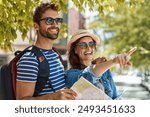 Happy couple, travel and city sightseeing in outdoor, map and urban vacation in Netherlands. People, pointing and explore town for adventure, sunglasses and search for direction or navigation