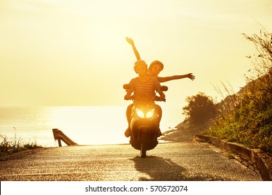 Happy couple traveling on motorcycle on sea coastal road. Travel concept