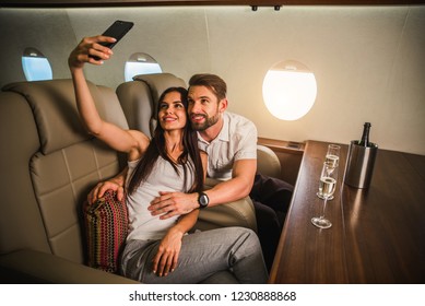 Happy Couple Travelling On A Luxury Private Jet - Young Adults Travel On A First Class Flight, Concepts About Travel And Lifestyle