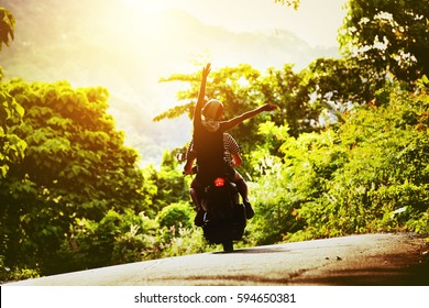 Happy couple tripping by motorcycle on tropical road at sunset time - Powered by Shutterstock