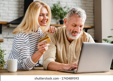 Happy couple using credit card for shopping online using laptop - Powered by Shutterstock