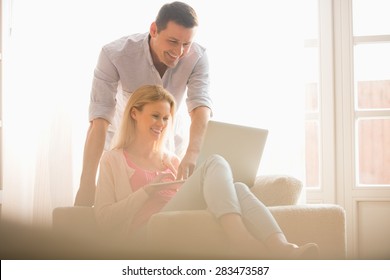 Happy Couple Using Laptop Together At Home