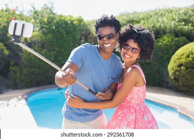 Happy Couple Using A Selfie Stick In The Garden At Home