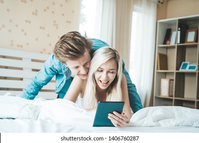 Happy couple Using tablet computer on the bed