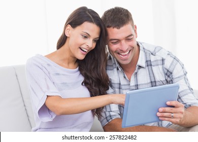 Happy couple using tablet PC together at home