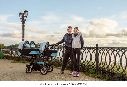 Happy Couple Walking With Their Triplets