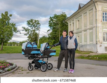 Happy Couple Walking With Their Triplets