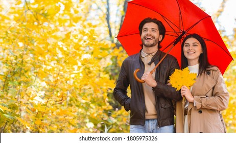 Happy couple walking under umbrella at rainy autumn day, free space - Powered by Shutterstock