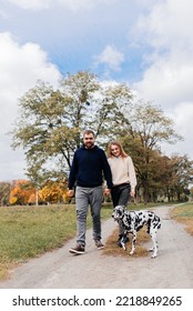 A Happy Couple Walks Their Dog Dalmation