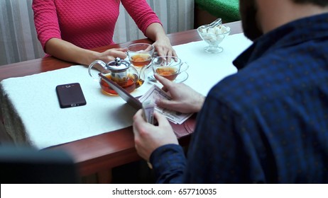 Happy Couple With Wallet Paying Bill At Restaurant With Dollar Cash