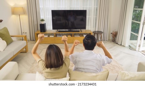 Happy Couple Watching A Movie On Tv Blank Screen In Living Room At Home Theater Room In A House. People Lifestyle.