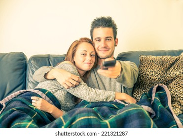 Happy Couple Watching Television On The Couch - Family,recreation,leisure,togetherness Concept