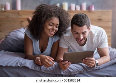 Happy couple watching their wedding photos on a tablet - Powered by Shutterstock