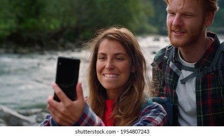 Happy Couple Waving Hands At Camera During Video Chat. Excited Man And Woman Showing Landscape In Mountains During Video Call. Positive Hikers Using Mobile Phone For Video Chat Online 