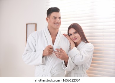Happy Paar mit Bademänteln am Fenster zu Hause