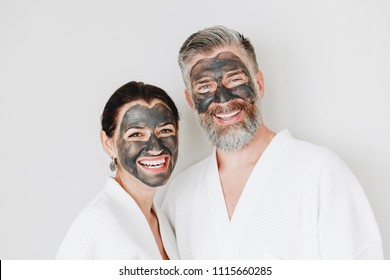 Happy couple wearing a charcoal mask