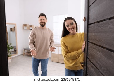 Happy couple welcoming at home. Invitation to come indoors - Powered by Shutterstock