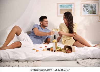 Happy Couple With Wine And Tasty Food Imitating Picnic At Home