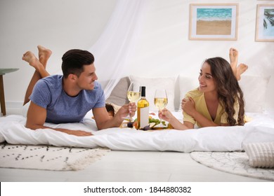 Happy Couple With Wine And Tasty Food Imitating Picnic At Home