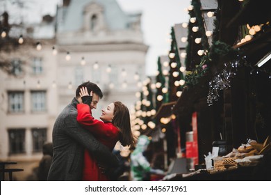 Casais felizes na praça da cidade decorados para um mercado de Natal