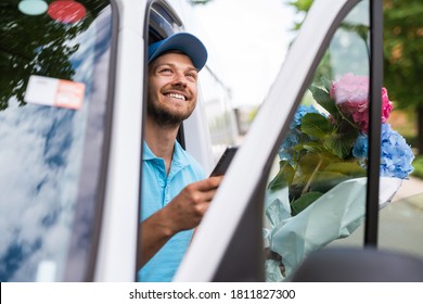 Happy courier inside the white van during flowers delivery is waiting for a client - Powered by Shutterstock