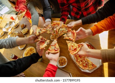 Happy Co-workers Celebrating While Company Party And Corporate Event. Young Caucasian People In Casual Clothes Eating Pizza. Concept Of Office Culture, Teamwork, Friendship, Holidays, Weekend. Top