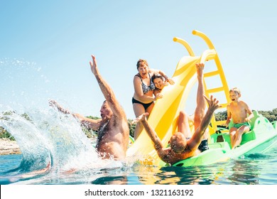 Happy crazy family hands up on floating Playground slide Catamaran as they enjoying sea trip as they have summer season vacation - Powered by Shutterstock