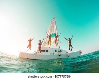 Happy crazy friends diving from sailing boat into the sea - Young people jumping inside ocean in summer vacation - Main focus on center guys - Travel and fun concept - Fisheye lens distortion - Shutterstock ID 1079757884