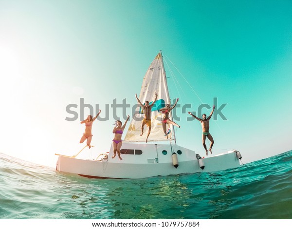 セーリングボートから海に飛び込む幸せな気が狂った友達 夏休みに海に飛び込む若い人々 中心の人々を中心にしたトラベルと楽しいコンセプ の写真素材 今すぐ編集