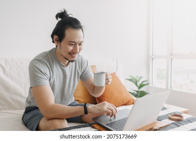 Happy Creative Asian Man Work On Laptop In His Home Office Apartment.