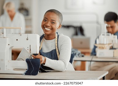 Happy, creative black fashion student or designer sitting and smiling in class by a sewing machine working on clothes. Isolated portrait of beautiful African American tailor in a factory or studio. - Powered by Shutterstock