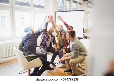 Happy creative business people giving high-five in meeting room at creative office - Powered by Shutterstock